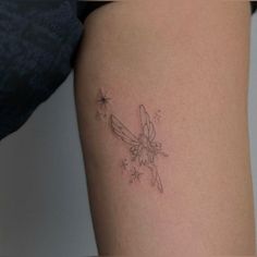 a small tattoo on the thigh of a woman's leg, with a bird and stars