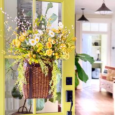 a basket filled with flowers sitting on top of a yellow door