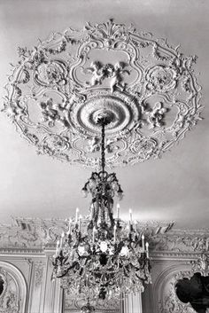 a chandelier hanging from the ceiling in a room with white walls and ceilings