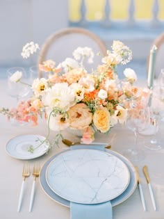 a table set with plates, silverware and flowers