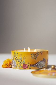 a yellow candle sitting on top of a white table