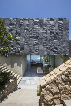 an outdoor area with stone walls and steps leading up to the house's entrance