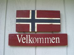 a wooden sign with the word velkommen written in white and red on it