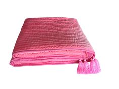 a pink blanket with tassels on it