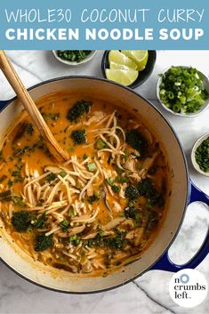 chicken noodle soup with broccoli and limes in a blue bowl on a marble countertop