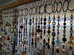 a wall covered in lots of different colored glass beads and chains hanging from it's sides