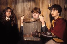 three harry potters are posing with a wooden barrel in front of their heads and hands