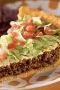 a piece of pie with lettuce and tomatoes on it sitting on a plate