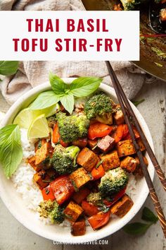 a white plate topped with tofu and broccoli next to chopsticks