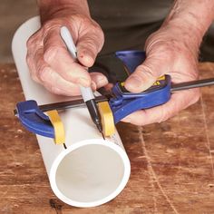 a man is using a pair of pliers on a piece of wood