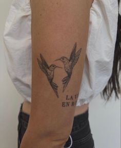 a woman's arm with two birds on it and the words la vie en arr