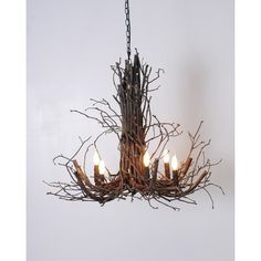 a chandelier made out of branches with candles in the center and one light on each side