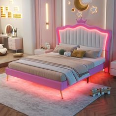 a bed with pink and white furniture in a room that is lit up at night