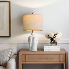 a living room with a couch, table and lamp on top of the coffee table