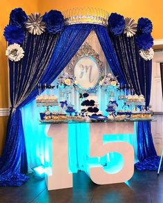 the table is decorated with blue and white decorations for an elegant 50th birthday party at home