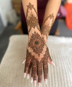 a woman's hand with henna tattoos on it