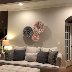 a living room filled with furniture next to a stair case and two wall hangings