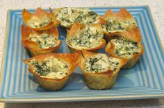 small cups filled with spinach and cheese on a blue plate