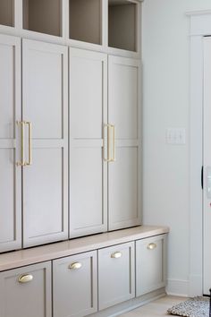 an empty room with white cabinets and drawers