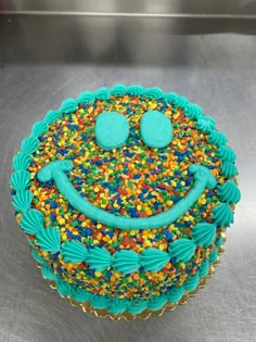 a birthday cake with sprinkles and a smiley face on it