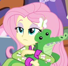 a pinkie is hugging a green alligator