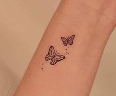 two small butterflies on the wrist tattoo design for women and girls, one is black