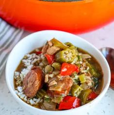 a white bowl filled with rice and vegetables next to an orange pot full of food