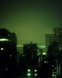 the city skyline is lit up at night, with buildings and skyscrapers in the foreground