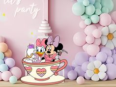 there is a cake and balloons in the room with minnie mouses on top of it