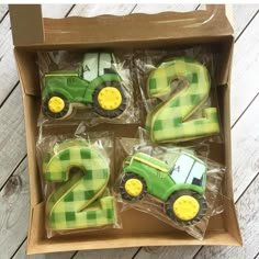 a box filled with green and yellow birthday cookies in the shape of numbers 2 - 3