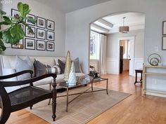 a living room filled with furniture and pictures on the wall