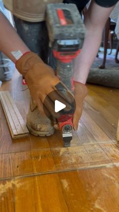 a person using a power tool on a wooden floor