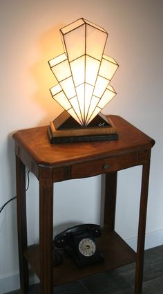 a table with a phone on it next to a lamp