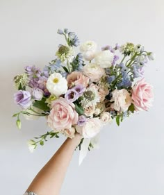 a woman's hand holding a bouquet of flowers