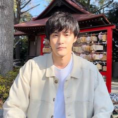 a young man standing in front of a red building