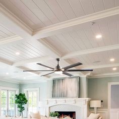 a living room filled with furniture and a fire place in the middle of it's ceiling