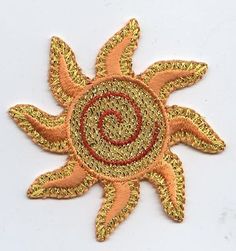 the sun is made out of gold and red thread with a circular design on it