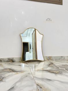 a bathroom mirror sitting on top of a marble counter