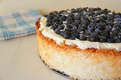 a cake with blueberries on top sitting on a table