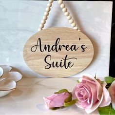 there is a sign that says andrea's suite next to some pink roses