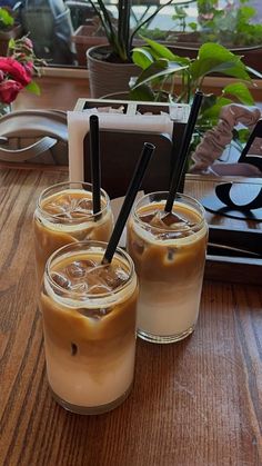 three drinks sitting on top of a wooden table