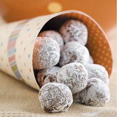 powdered donuts in a paper container on a table