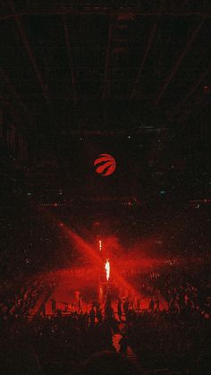 the audience at a concert is lit up with bright red lights and fans are seated in the bleachers