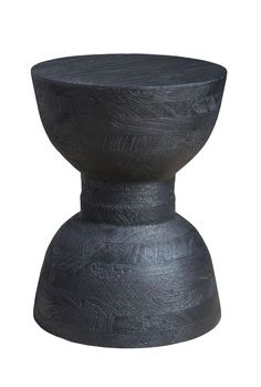 a black vase sitting on top of a white surface