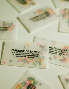 some business cards with confetti sprinkles on them are arranged neatly