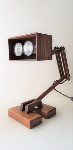 a desk lamp sitting on top of a wooden block next to a light bulb holder