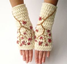 a pair of crocheted hand warmers with flowers on the wrist and fingers