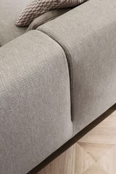 a close up of a couch with a pillow on top of it's back