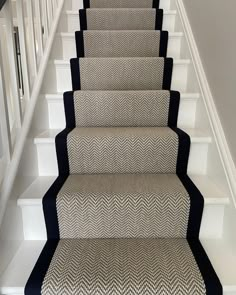 a carpeted staircase with black and white runnering