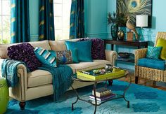 the living room is decorated in blue and green colors with colorful pillows on it's couches